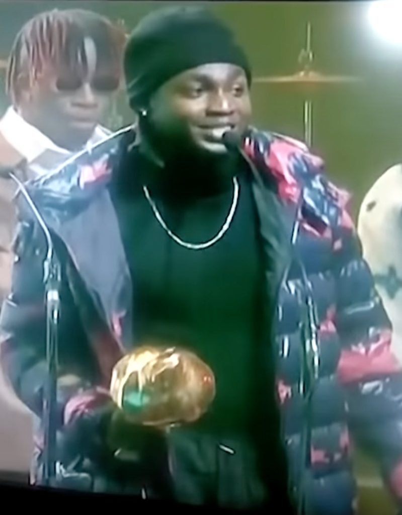 Omah Lay receiving the Next Rated award at the Headies