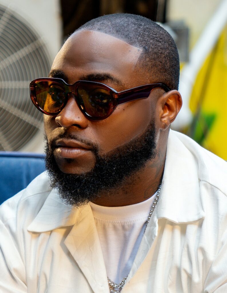 Davido in sunglasses and a cream shirt looking to the side