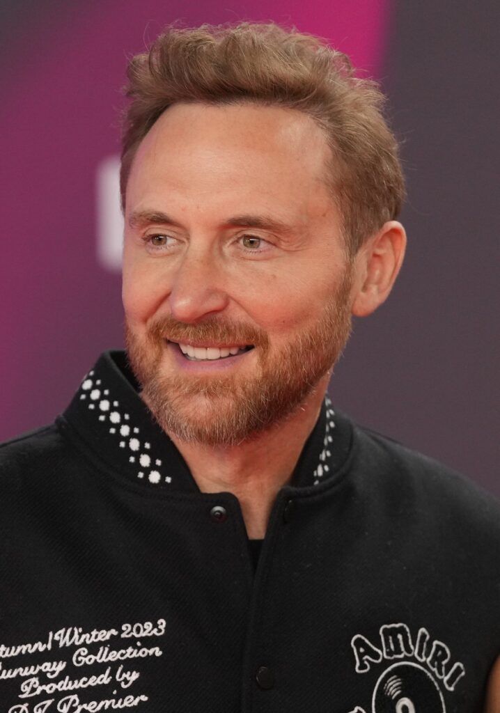 David Guetta smiling on a red carpet in a black jacket
