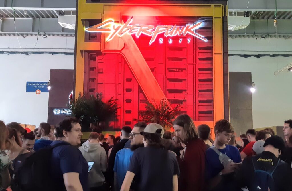 A large Cyberpunk 2077 stand with neon signage at a games fair
