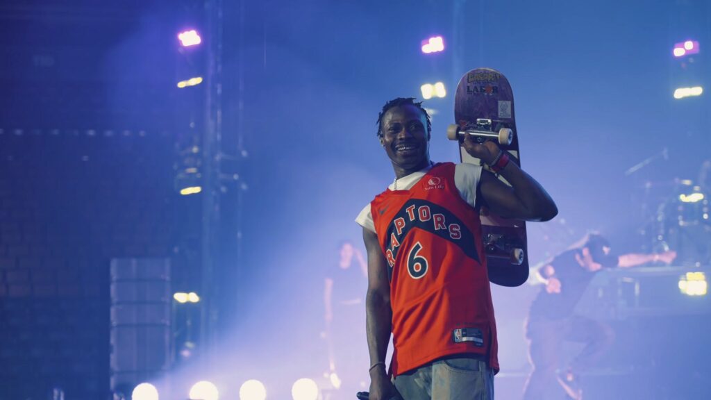 Asake performing on stage under blue lights in Toronto