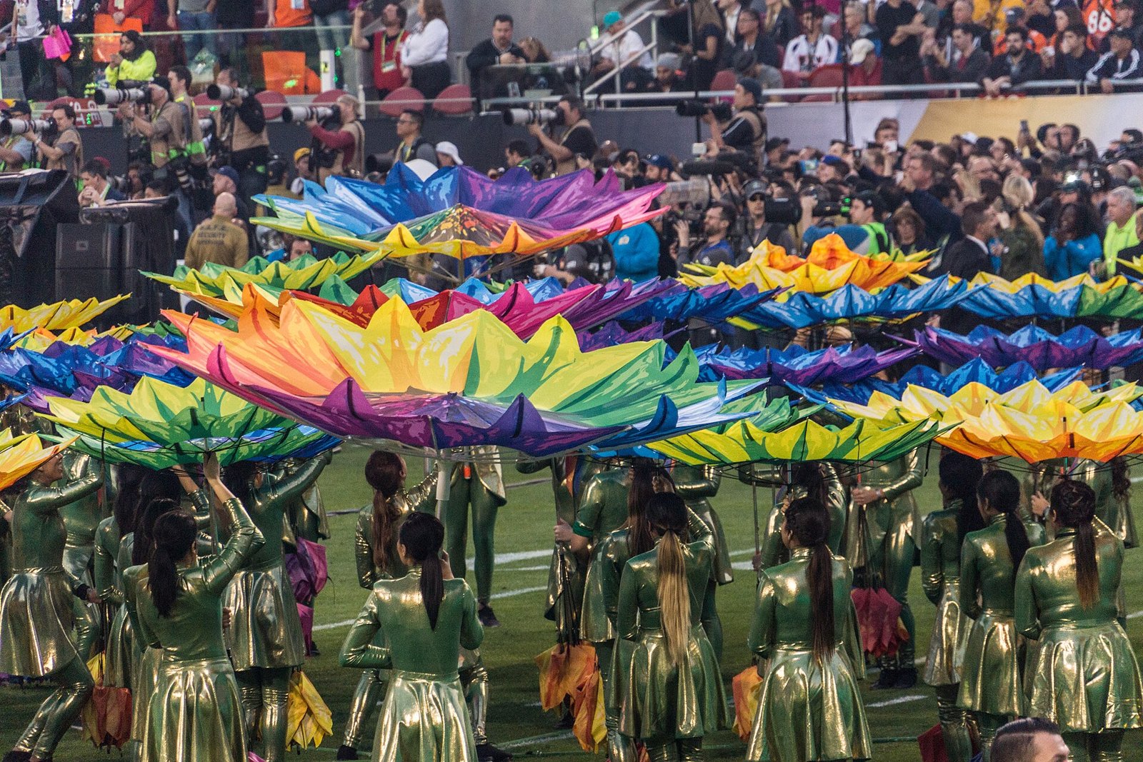 Dancers with giant colourful flower props on the field during the Super Bowl 50 halftime show in 2016