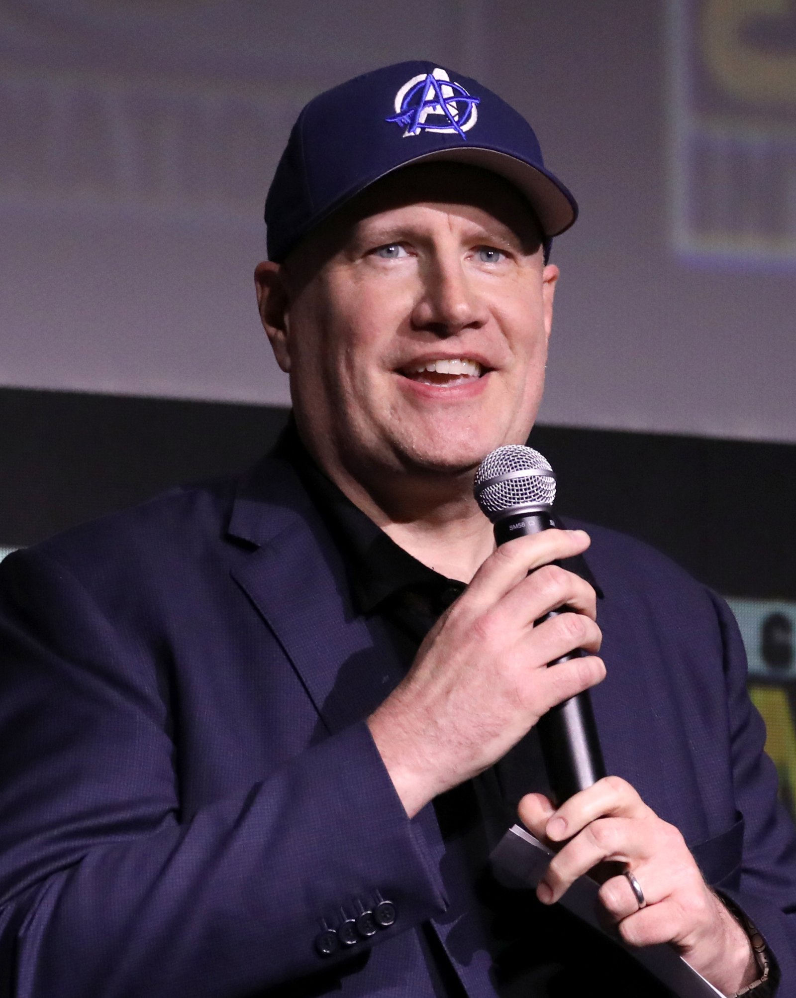 Marvel Studios president Kevin Feige speaking at a microphone at San Diego Comic-Con in 2024